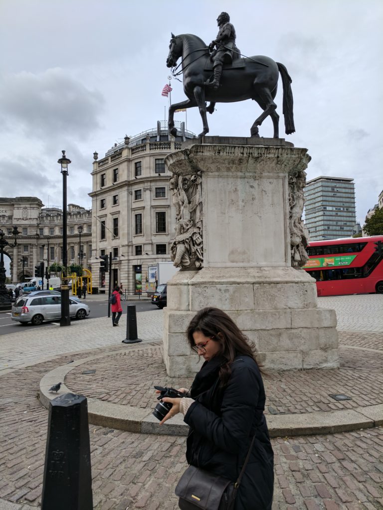 Sarah looking at her photos in Trafalgar Square