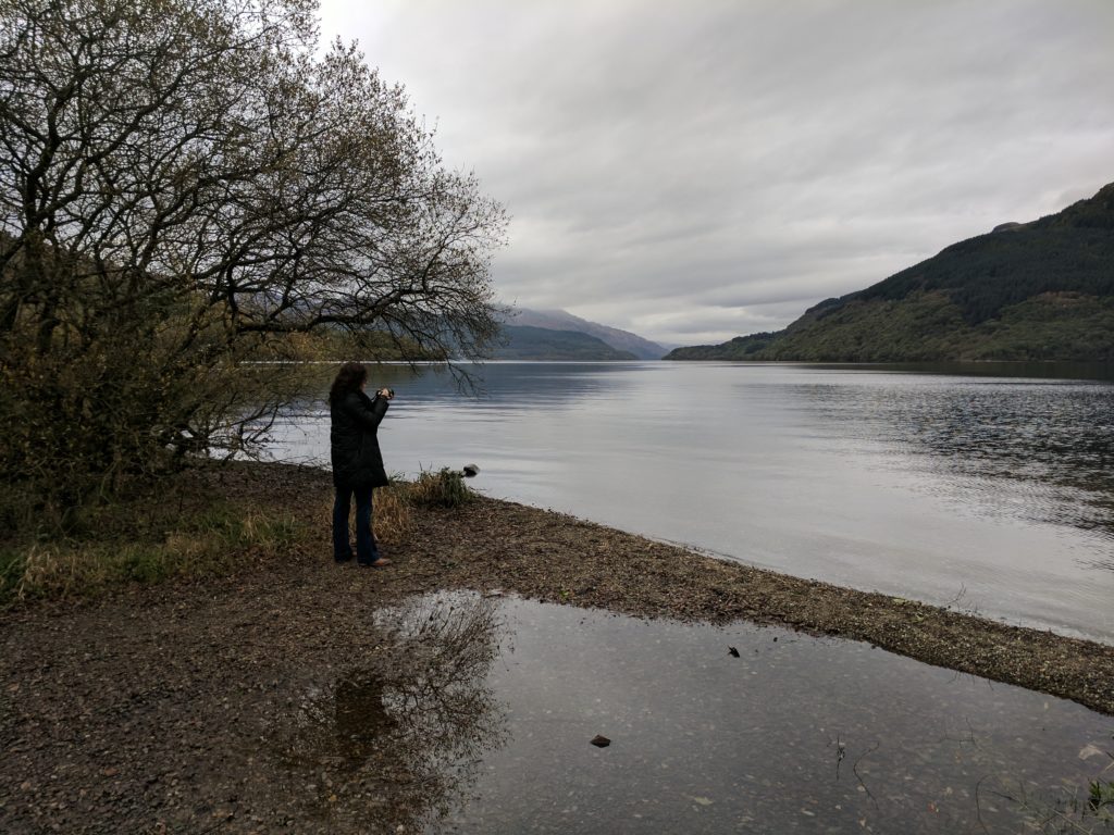 Sarah taking a photo at Loch Lomond, looking out over the large lake