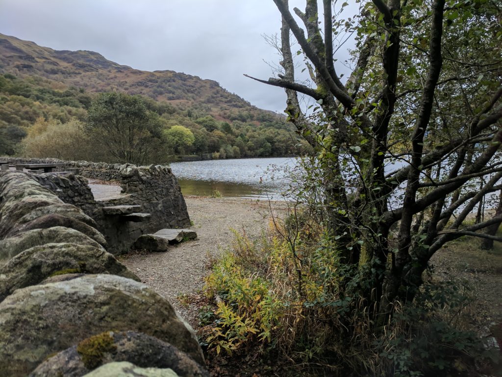 A stone wall and steps down to a beach area at Loch Lomond